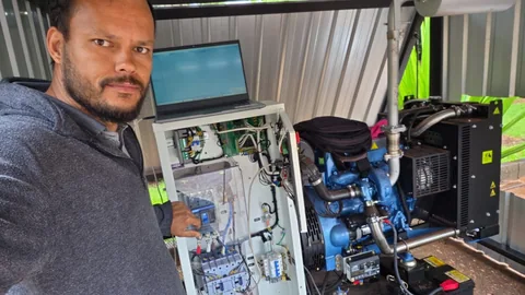 Profissional junto a um grupo gerador aberto, com motor e painel visíveis