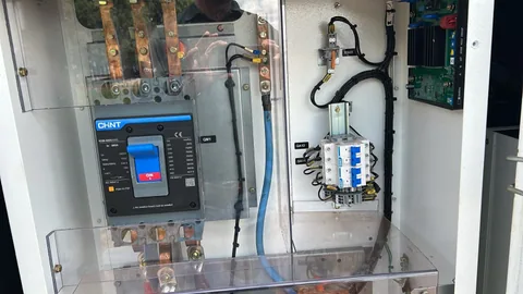 Interior de quadro elétrico com disjuntor, barramentos e cabeamento
